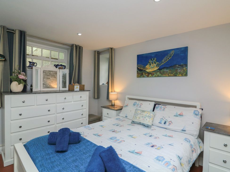 A bedroom with a bed and dresser at Hidden Treasure in Brixham