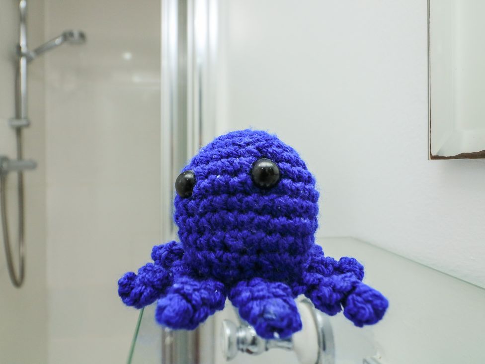A crocheted octopus on a towel rack in the bathroom at Hidden Treasure Brixham