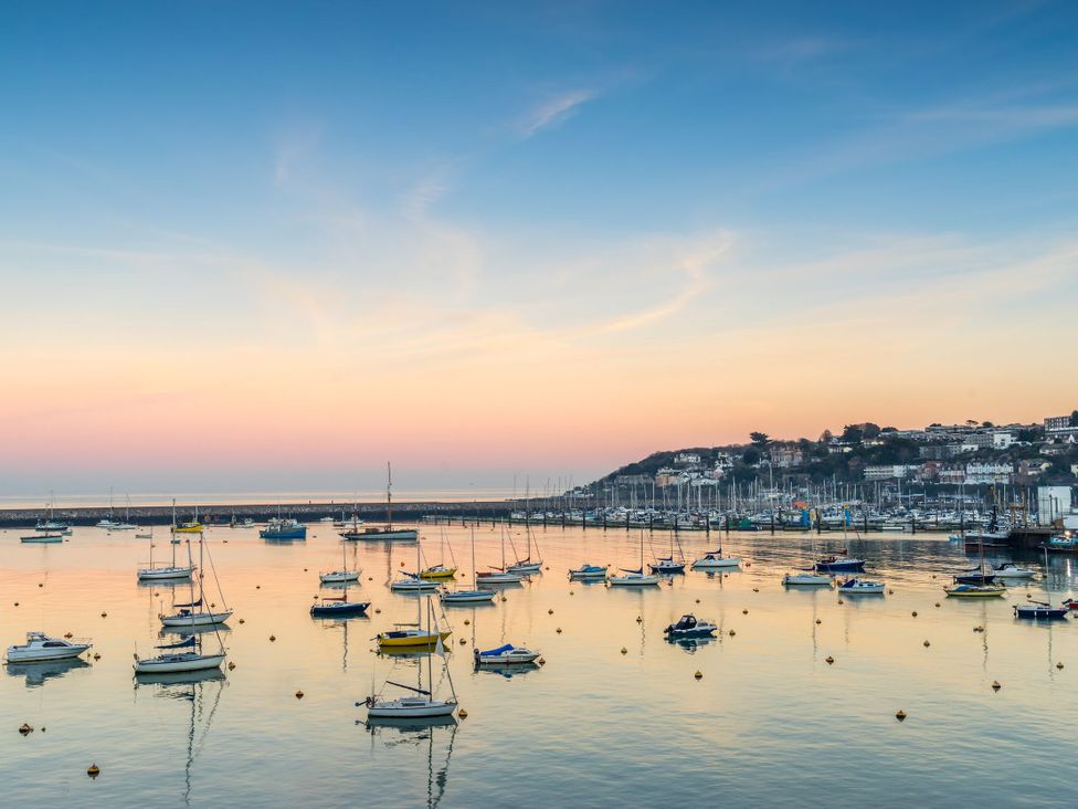 A view of sailboats in a marina during sunset at Hidden Treasure in Brixham