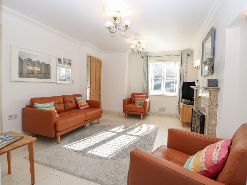 A living room with sofas, a coffee table, and a television at 5 Styleman Road in Hunstanton