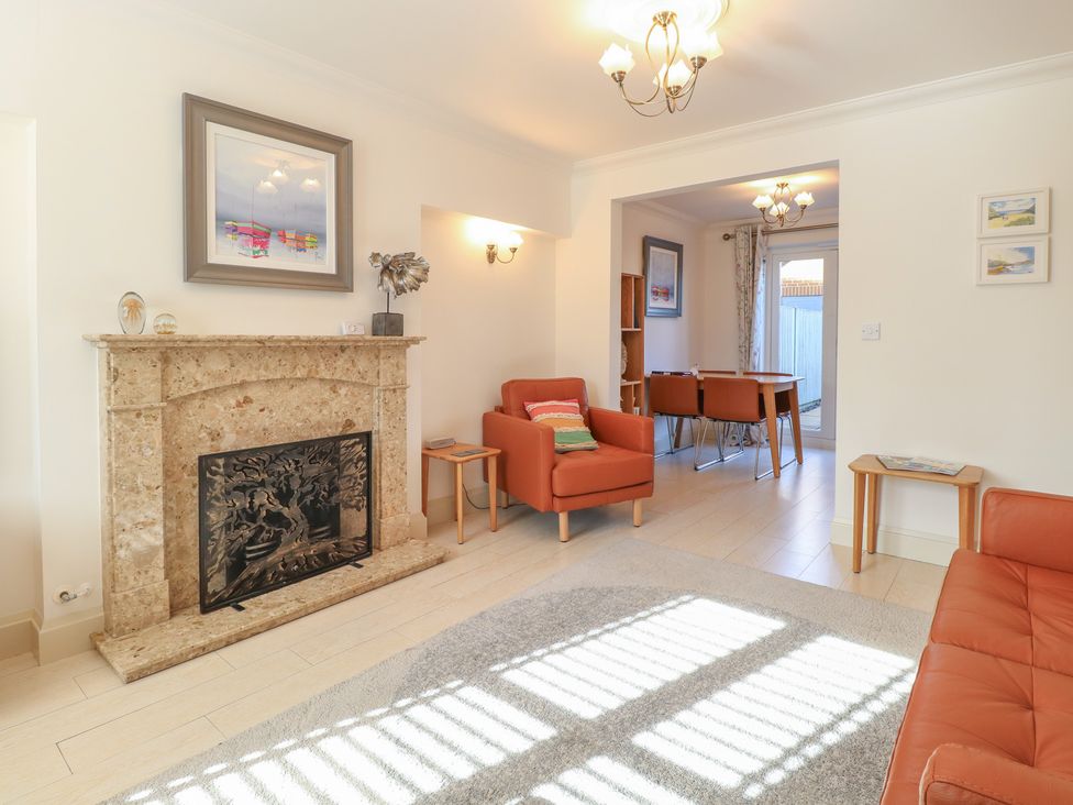 A living room with a fireplace and armchairs at 5 Styleman Road in Hunstanton