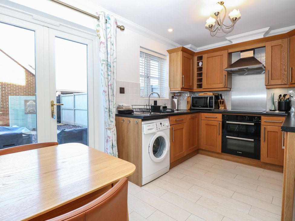 A kitchen with a table and chairs at 5 Styleman Road Hunstanton