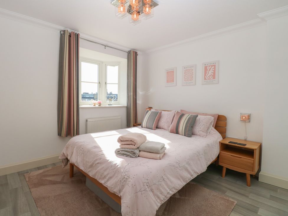 A bedroom with a bed and curtains at 5 Styleman Road in Hunstanton