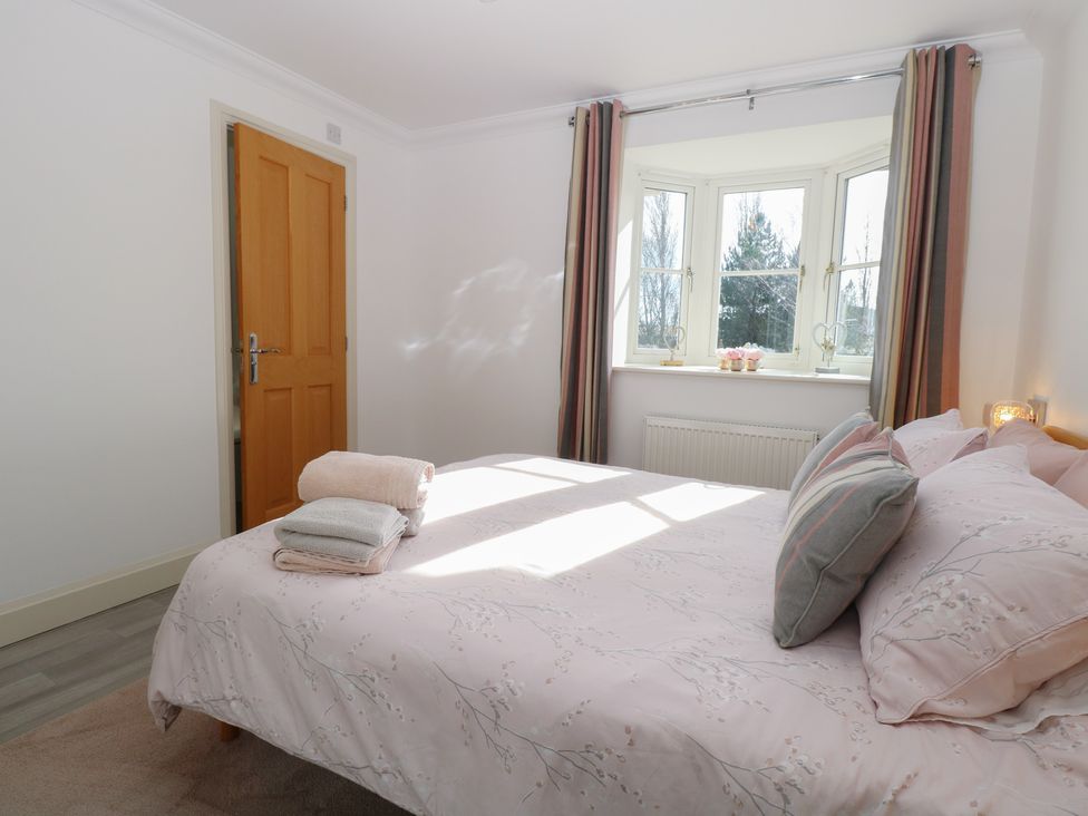 A bedroom with a bed and window at 5 Styleman Road Hunstanton