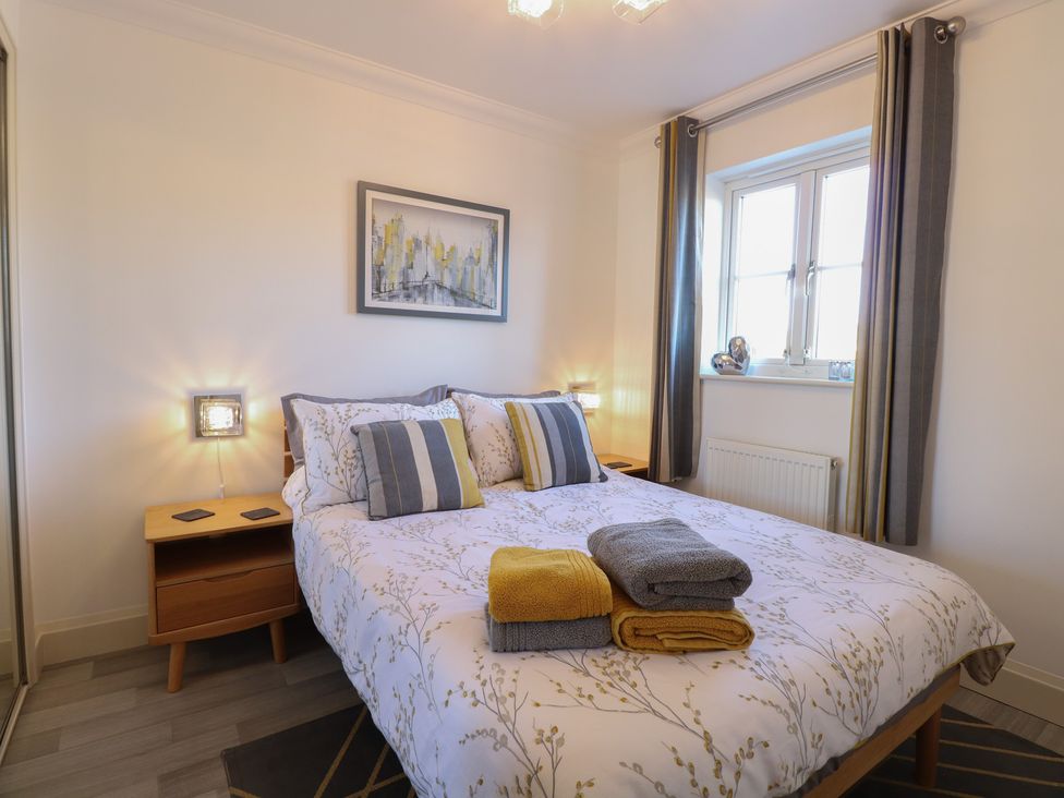 A bedroom with a bed and nightstand at 5 Styleman Road Hunstanton