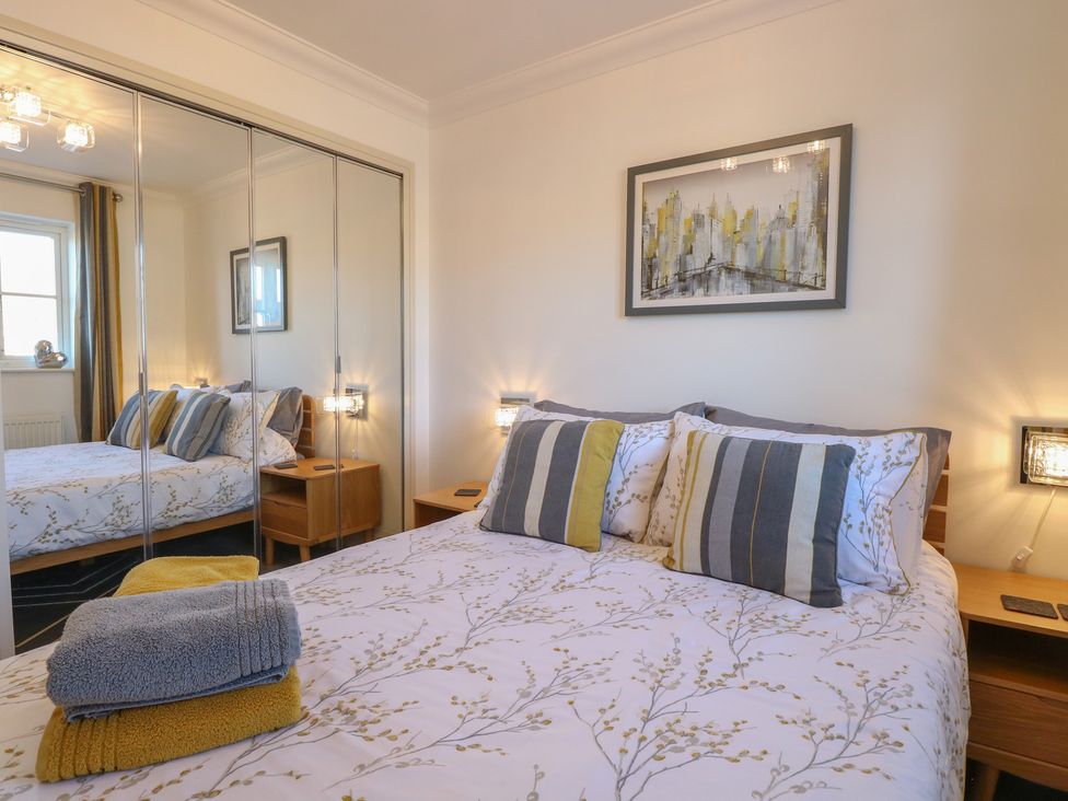 A bedroom with a bed and bedside table at 5 Styleman Road, Hunstanton