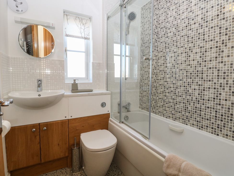 A bathroom with a bathtub, shower, sink, and toilet at 5 Styleman Road in Hunstanton