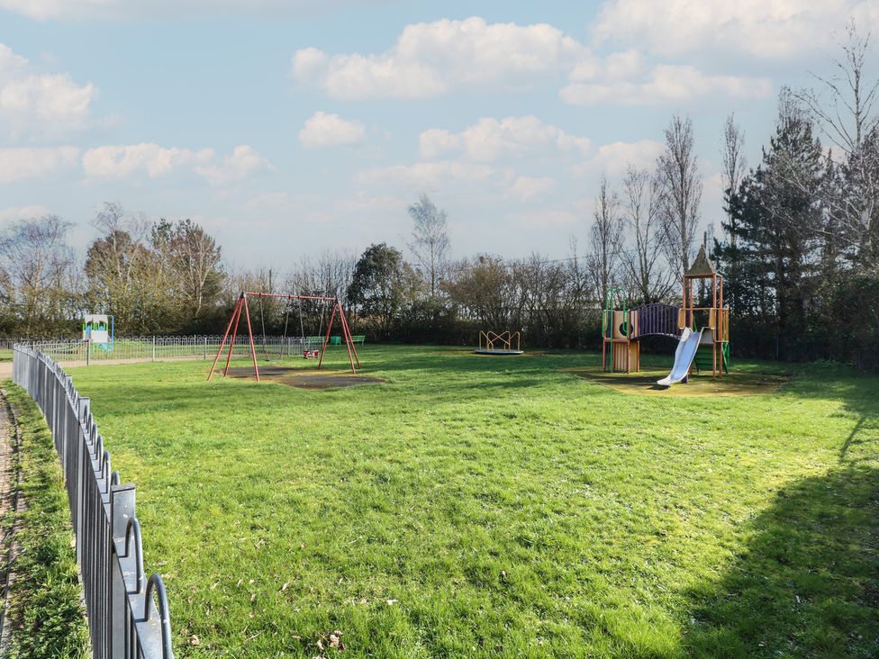 A playground with swings and slide at 5 Styleman Road in Hunstanton