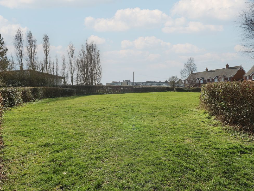An open area with grass and hedges near houses at 5 Styleman Road Hunstanton