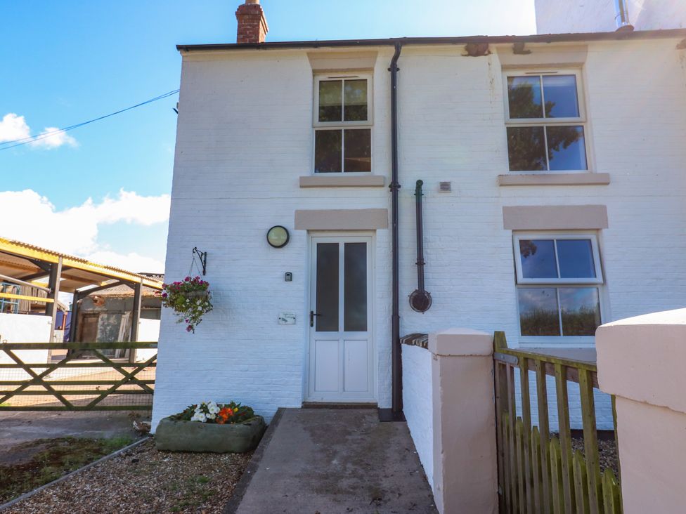 A front entrance with a door and windows at Tight Lyne Cottage in Longtown