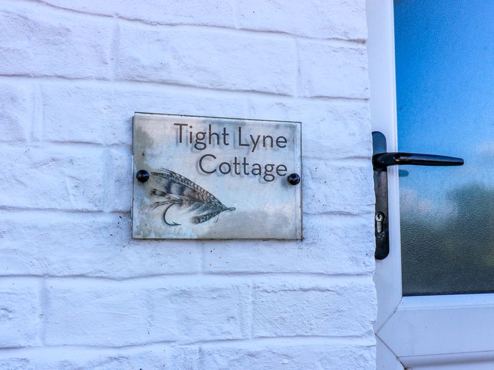 A nameplate for Tight Lyne Cottage next to a door at Tight Lyne Cottage Longtown