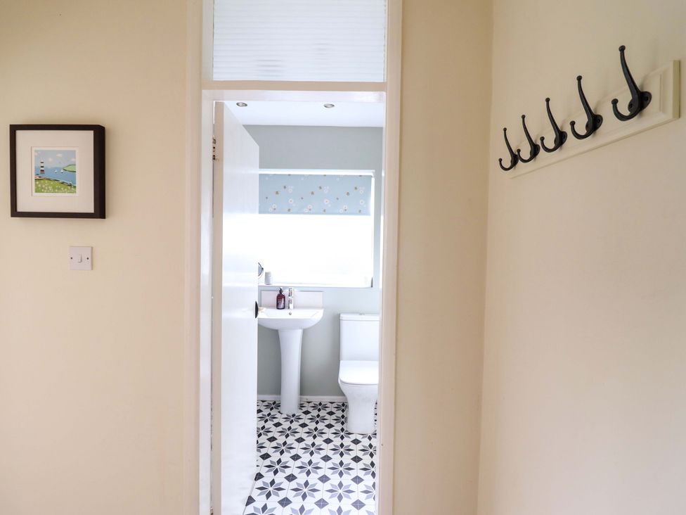 A bathroom with a sink and toilet visible at Castle Cove in Abergele
