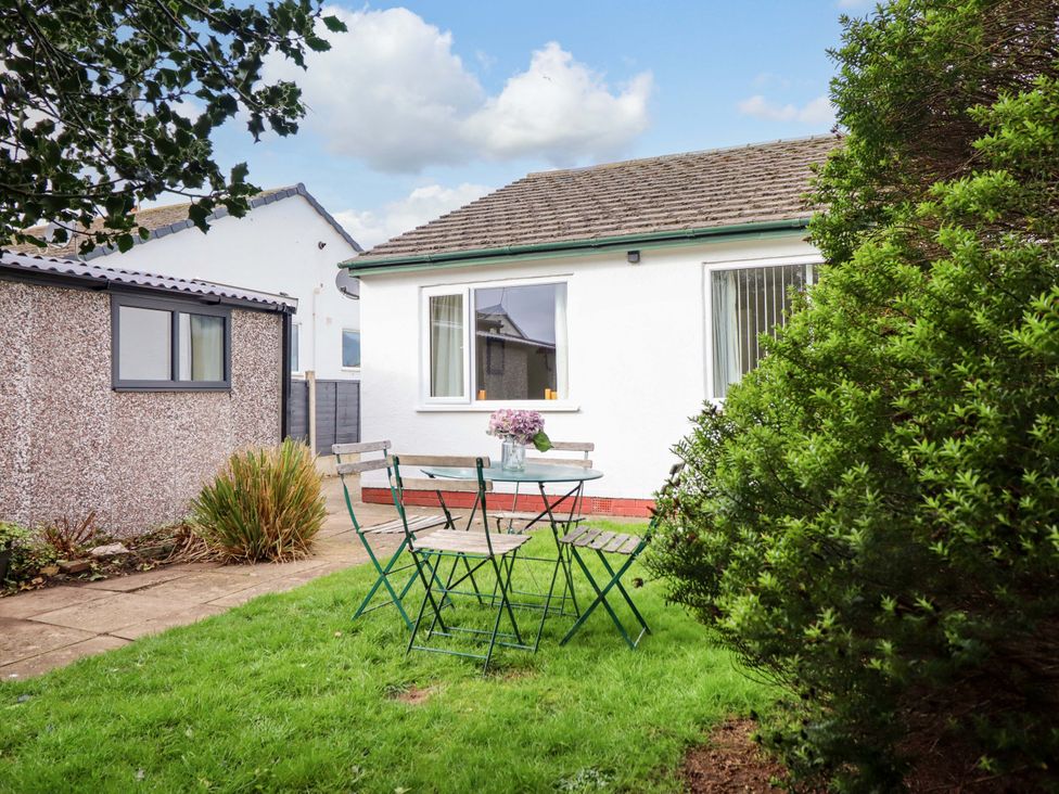 A garden with a table and chairs at Castle Cove in Abergele