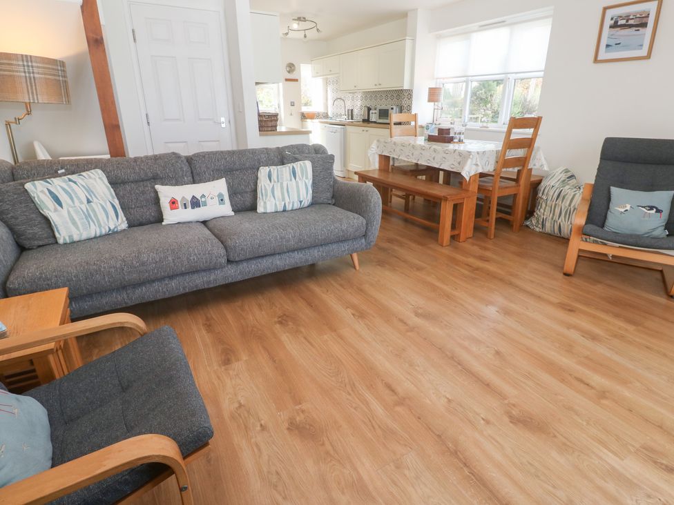 A living room with a sofa and dining area at Pilchard Cottage in Sennen Cove