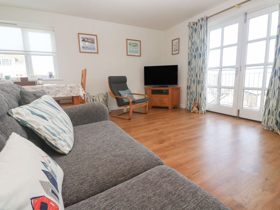 A living room with a sofa and TV at Pilchard Cottage in Sennen Cove