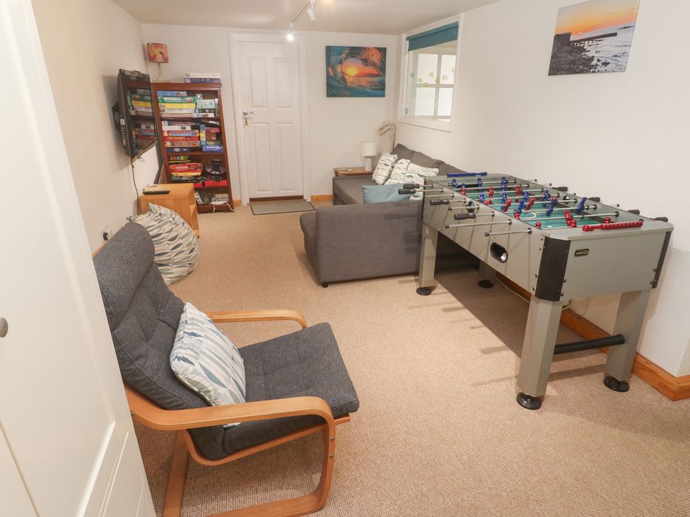 A game room with a foosball table and seating at Pilchard Cottage in Sennen Cove