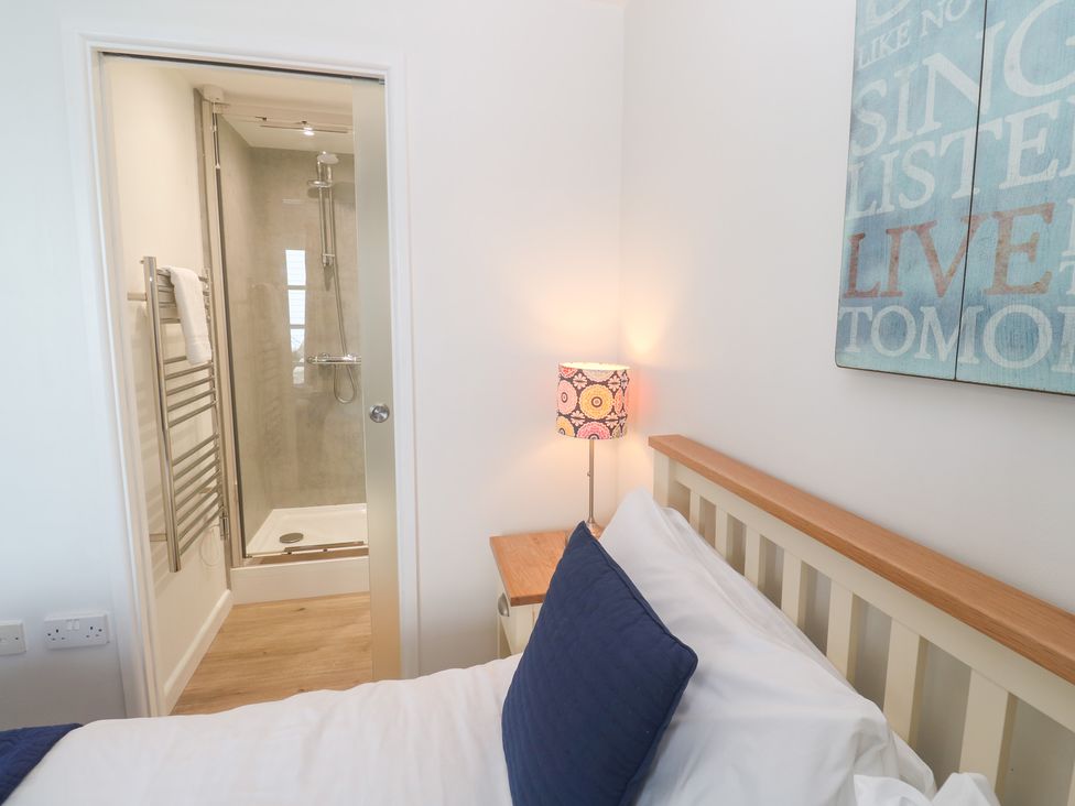 A bedroom with a shower and lamp at Pilchard Cottage in Sennen Cove