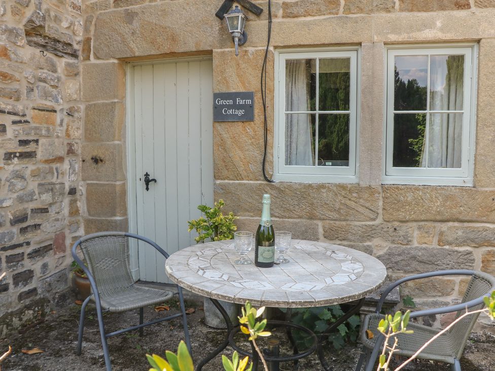 An outdoor seating area with a table and chairs at Green Farm Cottage in Hognaston near Carsington Water