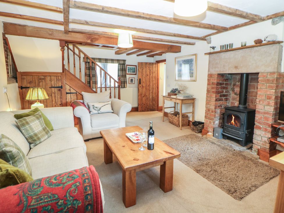 A living room with a fireplace and sofa at Green Farm Cottage Hognaston near Carsington Water