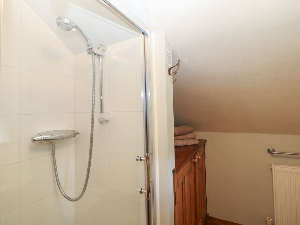 A shower with towels on a cabinet at Green Farm Cottage Hognaston near Carsington Water