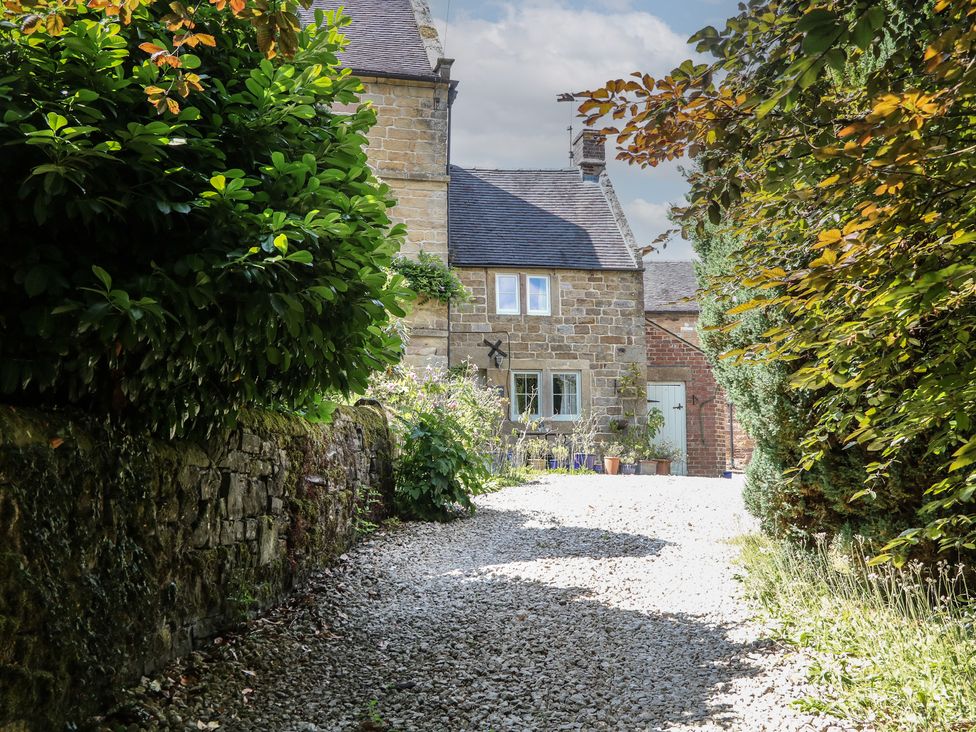 A pathway leading to a house surrounded by greenery at Green Farm Cottage Hognaston near Carsington Water