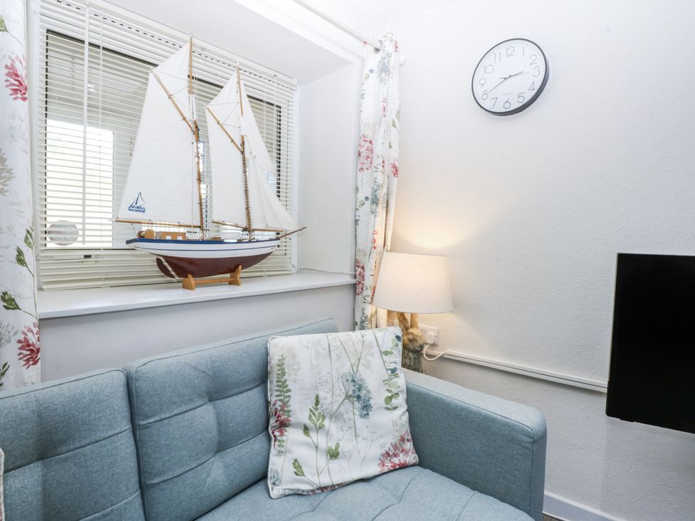 A living room with a model ship on a windowsill at 3 Tyn Giat Penysarn near Amlwch