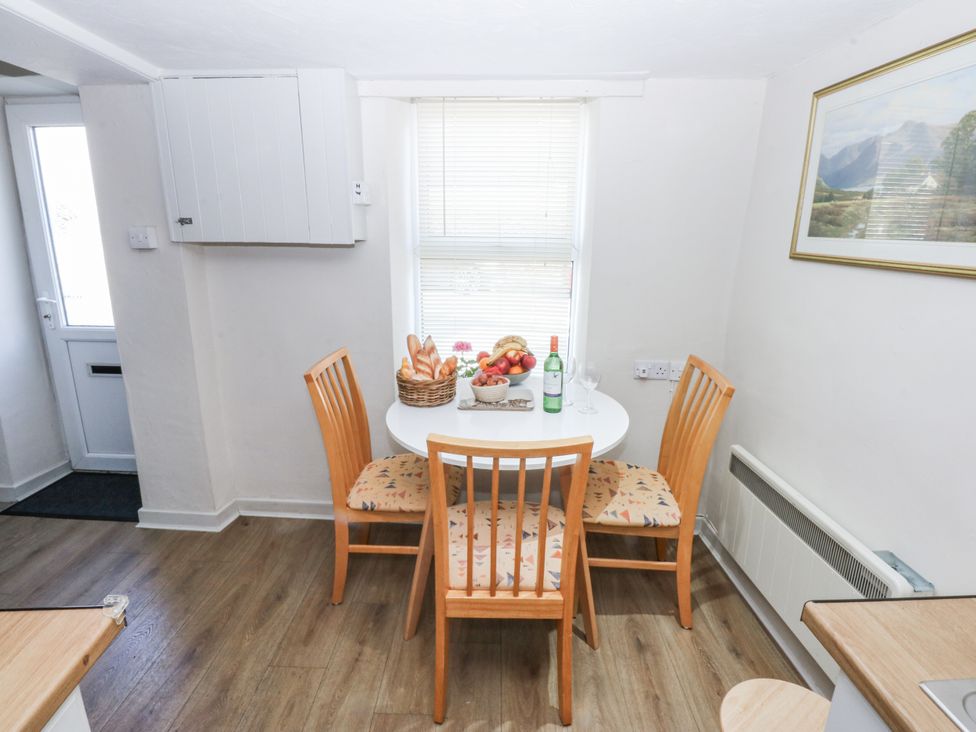 A kitchen with a dining table and chairs at 3 Tyn Giat Penysarn near Amlwch