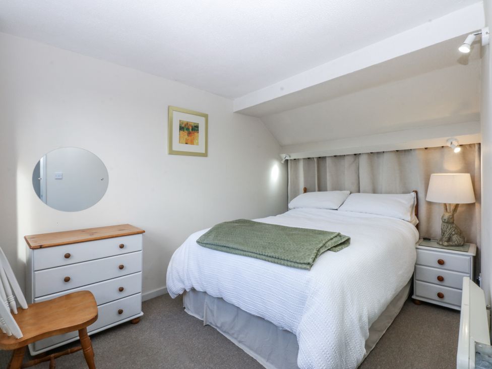 A bedroom with a bed and dresser at 3 Tyn Giat, Penysarn near Amlwch