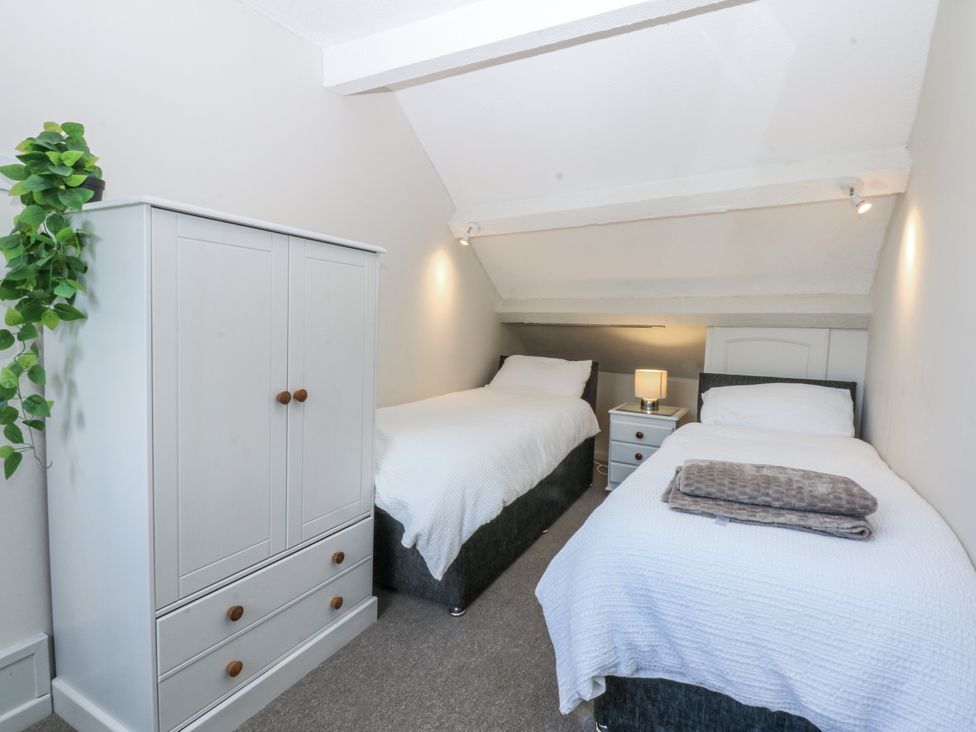 A bedroom with two single beds and a wardrobe at 3 Tyn Giat in Penysarn near Amlwch