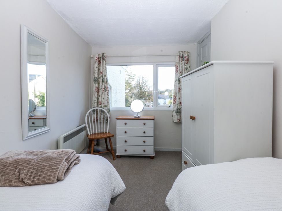 A bedroom with a bed, dresser, and window at 3 Tyn Giat Penysarn near Amlwch