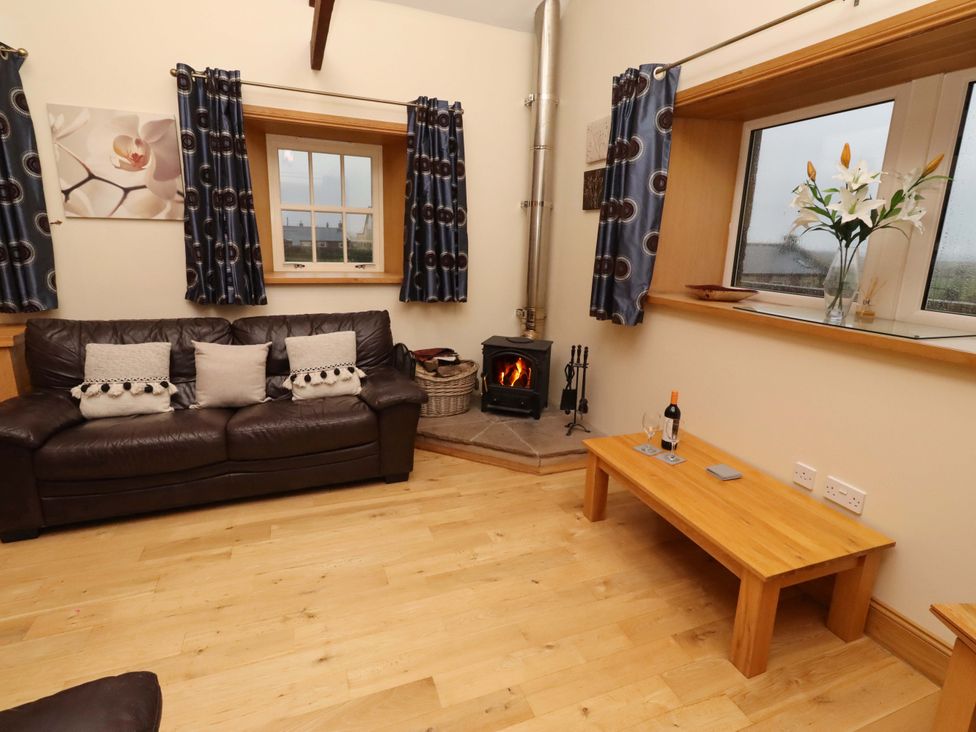 A living room with a sofa and a fireplace at Stable D'or in Embleton