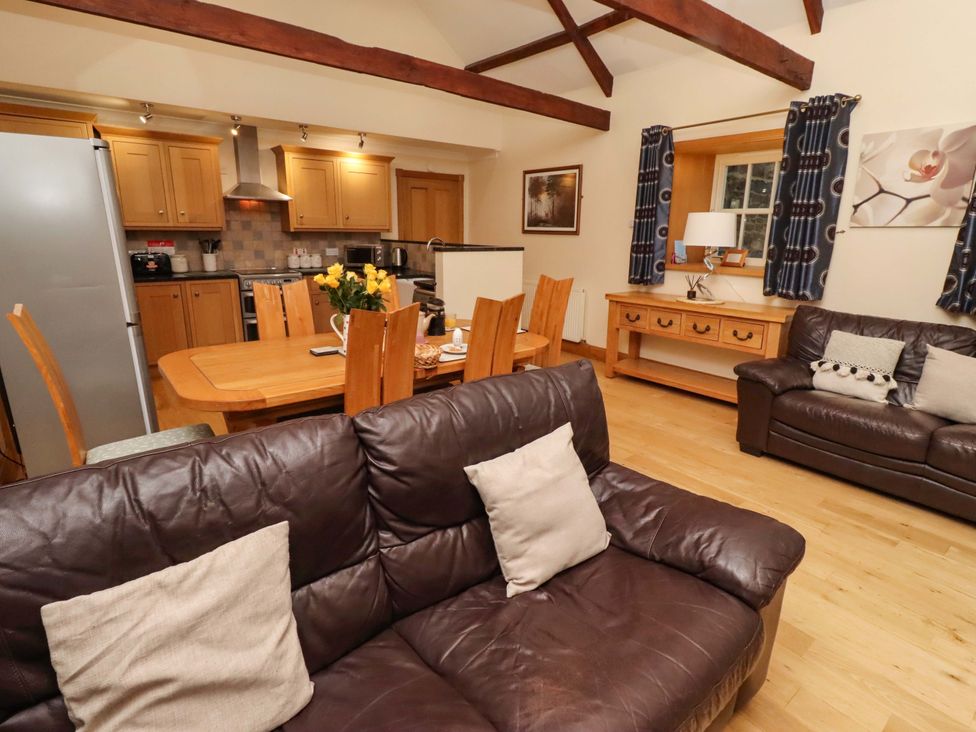 A living room with a dining area and kitchen at Stable D'or in Embleton