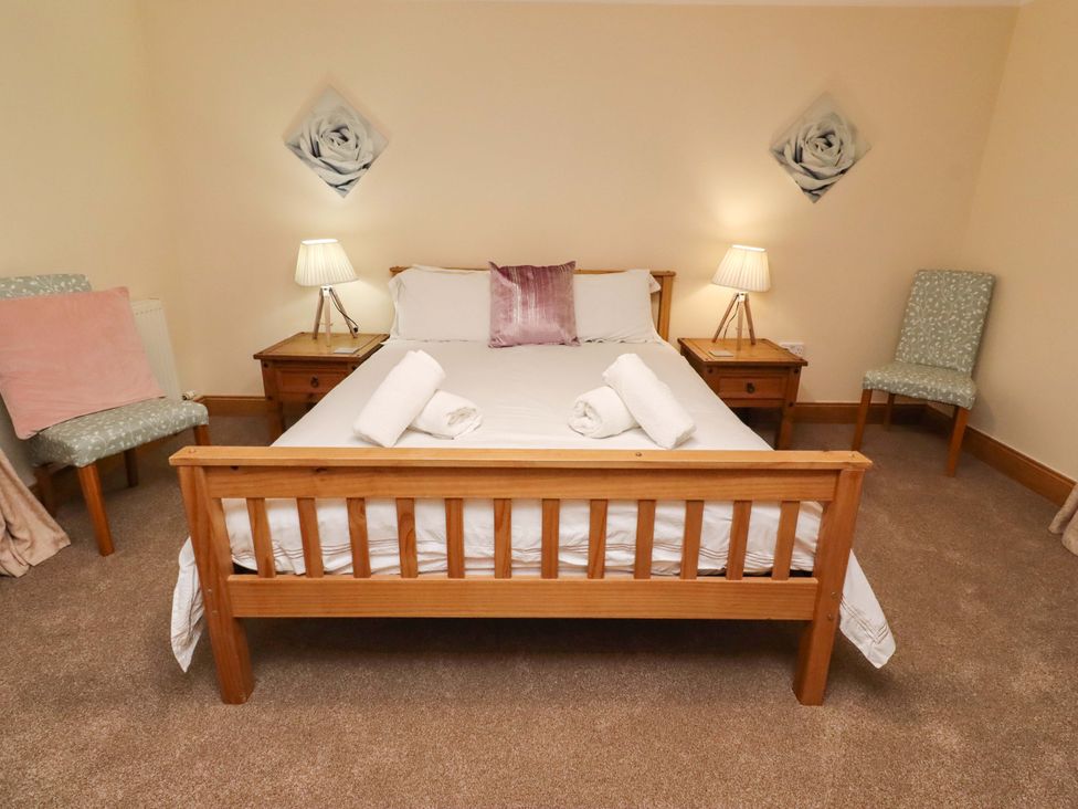 A bedroom with a bed and nightstands at Stable D'or in Embleton