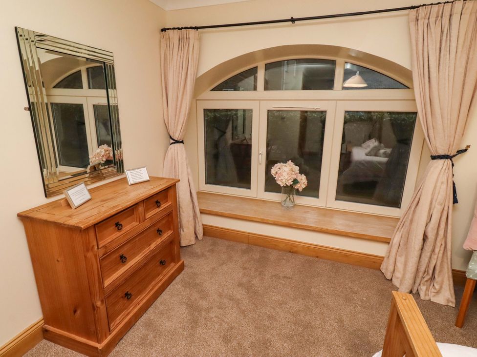 A bedroom with a dresser and a window at Stable D'or in Embleton