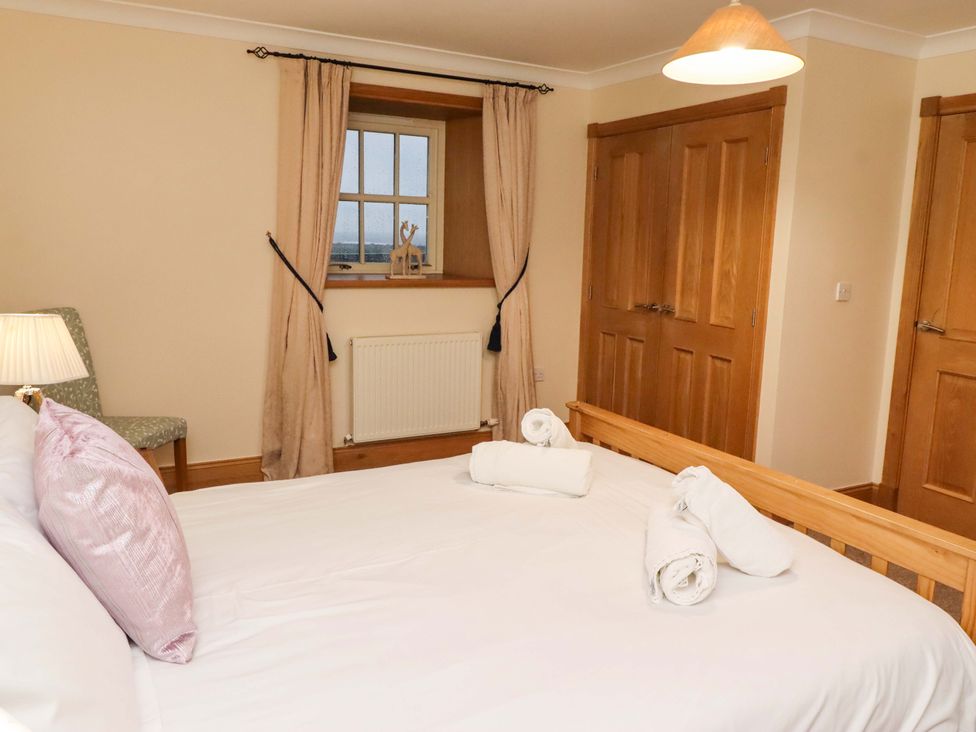 A bedroom with a bed and lamp at Stable D'or in Embleton