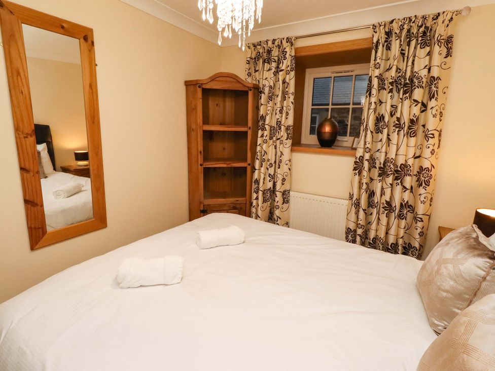 A bedroom with a bed and bookshelf at Stable D'or in Embleton