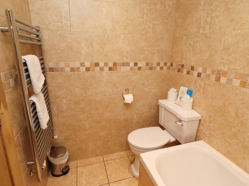 A bathroom with a toilet and bath tub at Stable D'or in Embleton