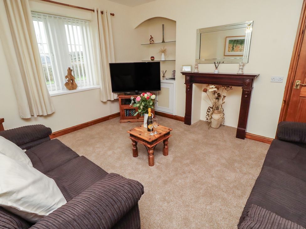 A living room with a television and a table at The Retreat in Embleton