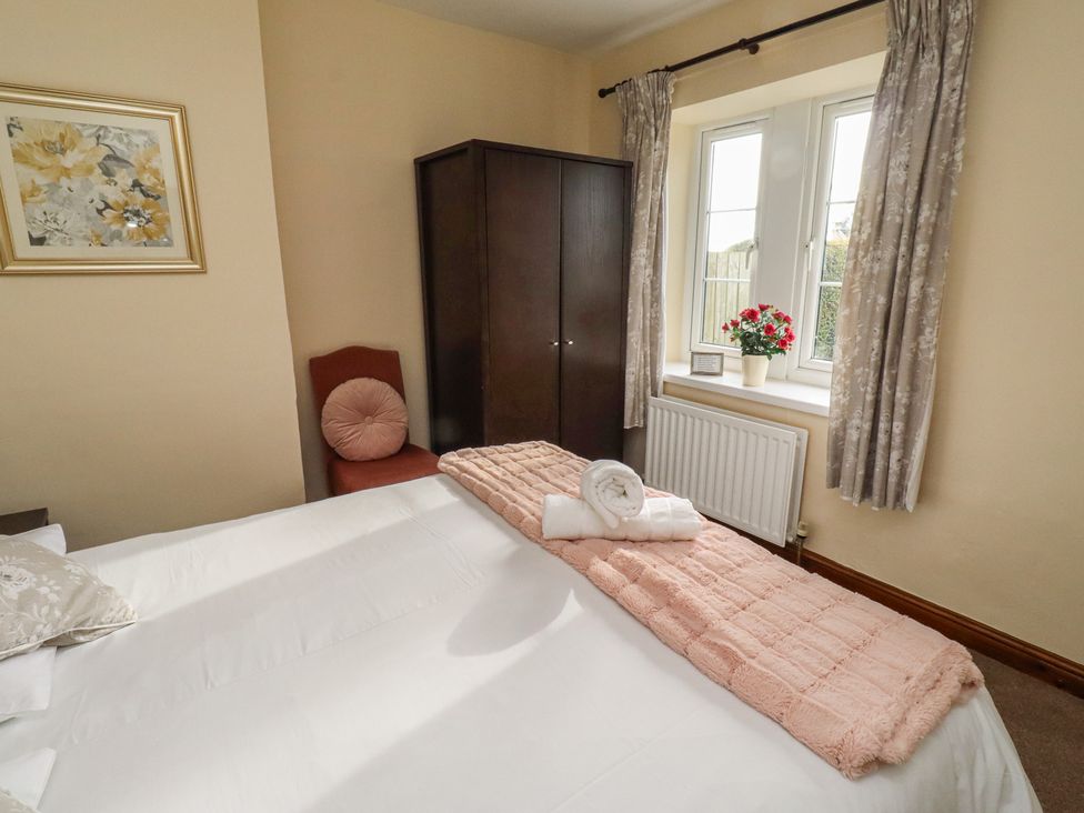 A bedroom with a bed and a closet at The Retreat in Embleton