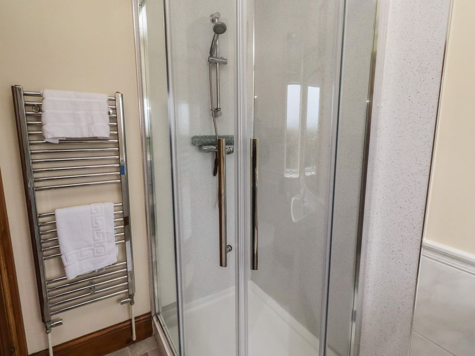 A shower and towel rail in a bathroom at The Retreat in Embleton