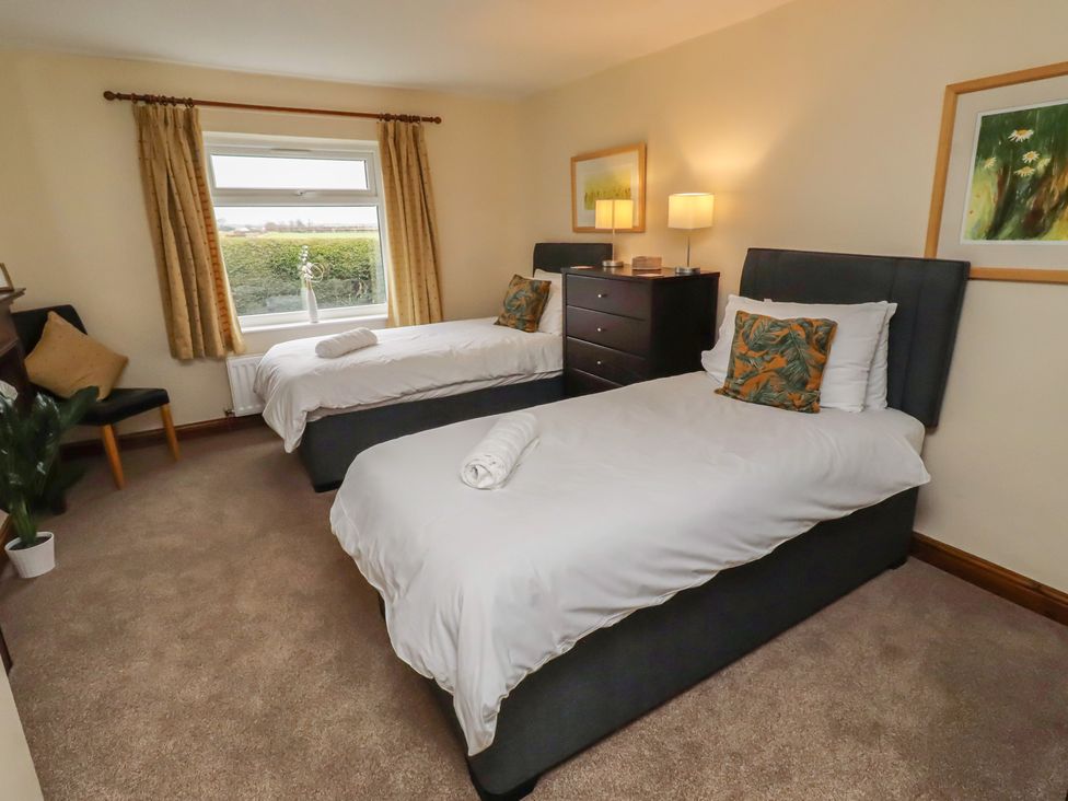 A bedroom with two single beds and a window at The Retreat in Embleton