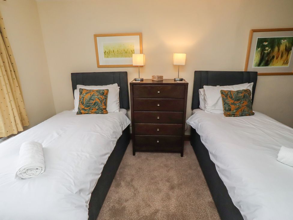 A bedroom with two single beds and a chest of drawers at The Retreat Embleton