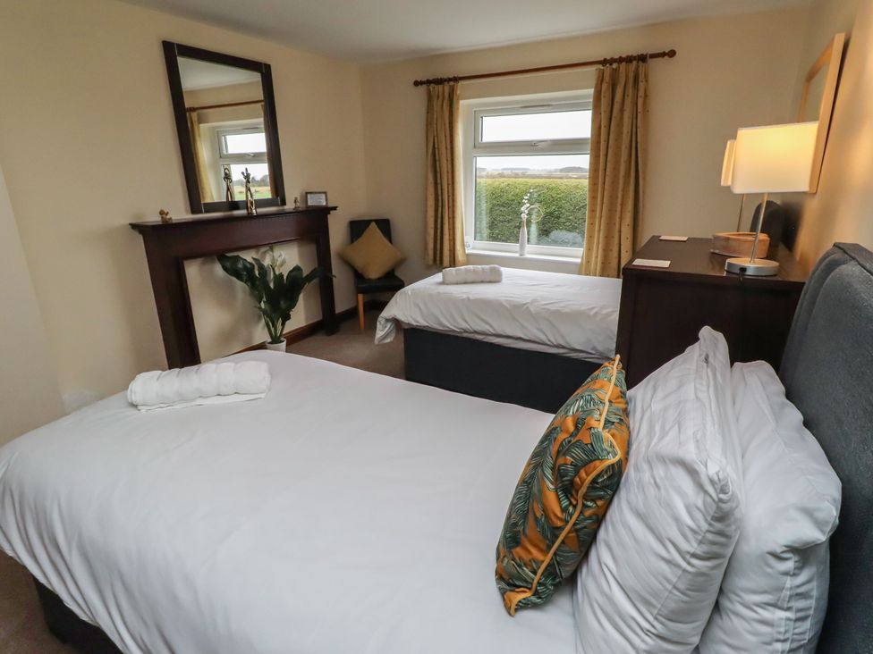 A bedroom with two beds and a window at The Retreat in Embleton