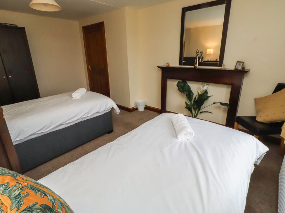 A bedroom with two beds and a wardrobe at The Retreat in Embleton