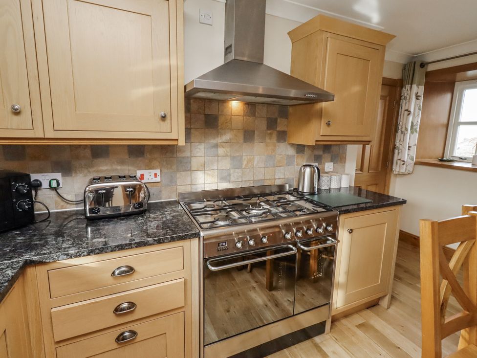 A kitchen with cabinets and a gas stove at Low Croft in Embleton