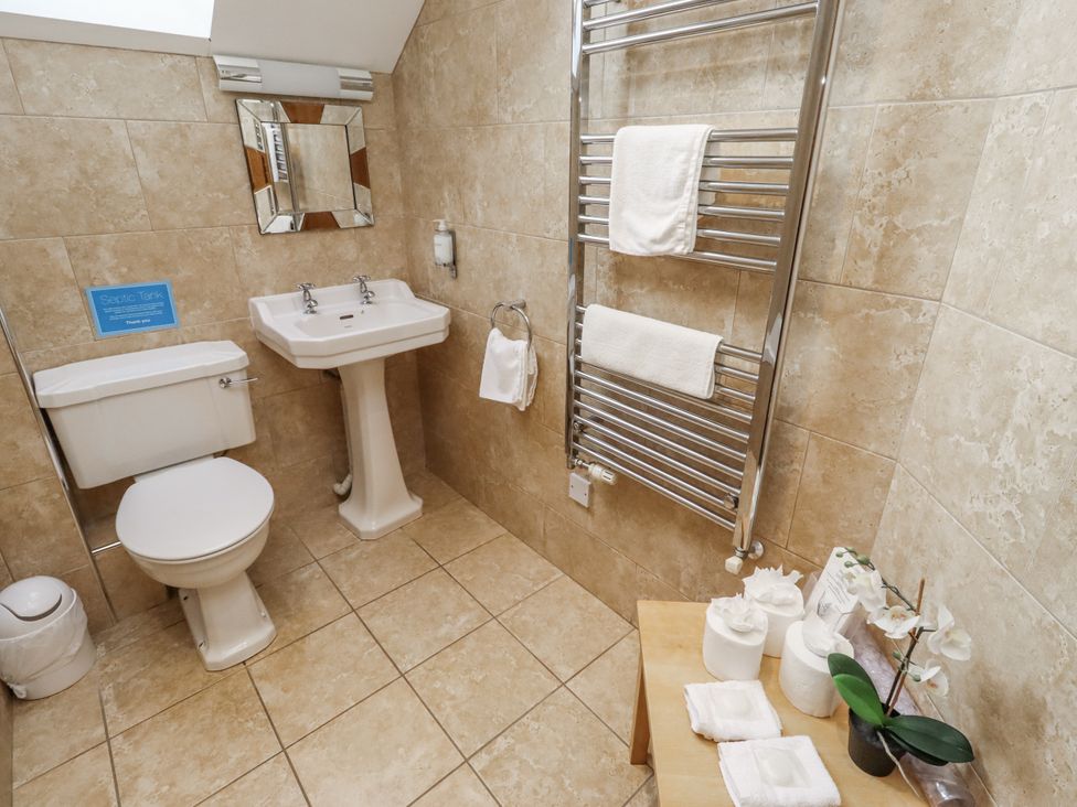 A bathroom featuring a sink, toilet, and towel rail at Low Croft in Embleton