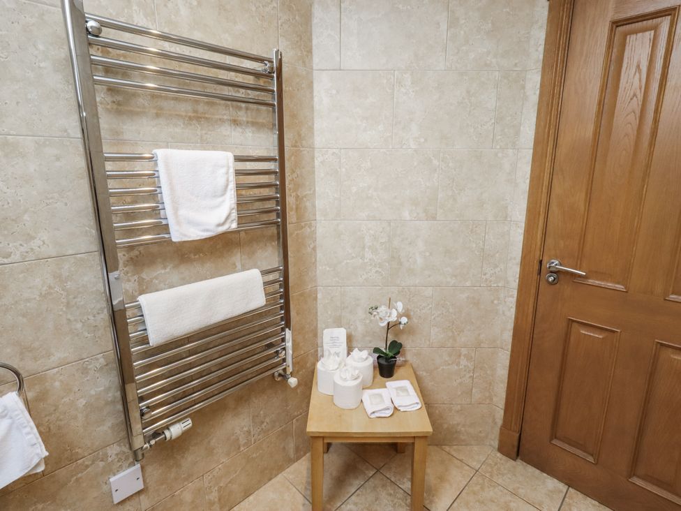 A bathroom with a towel rail and small table at Low Croft in Embleton