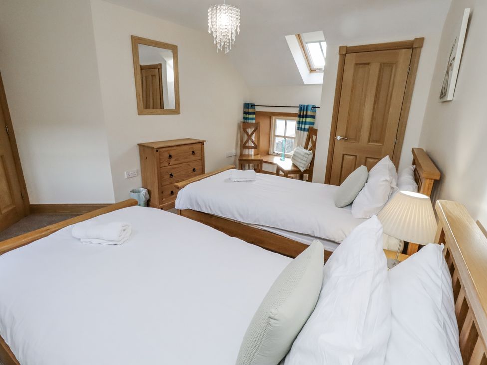 A bedroom with two beds and a dresser at Low Croft in Embleton