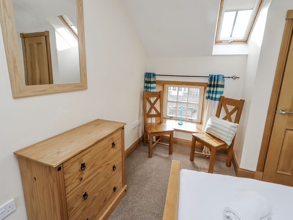 A bedroom with a chest of drawers and two chairs at Low Croft in Embleton