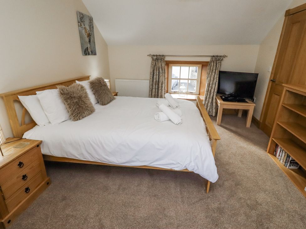 A bedroom with a bed, television, and dresser at Low Croft in Embleton